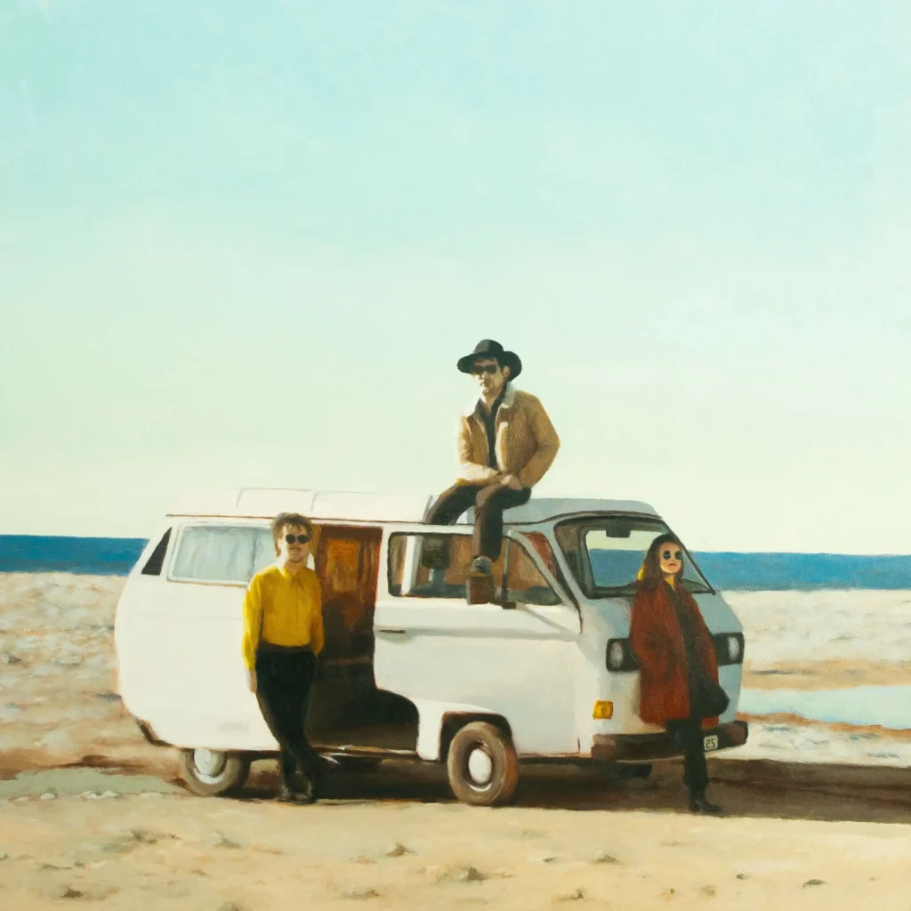Les 3 artistes minuscules, dont un assis sur un van