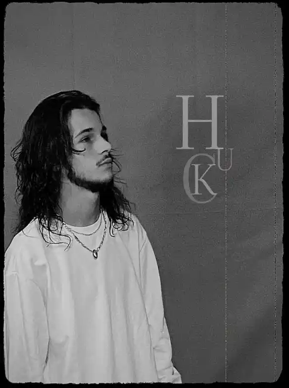Photo de HUCKLEBERRY qui regarde vers la droite vers son logo 